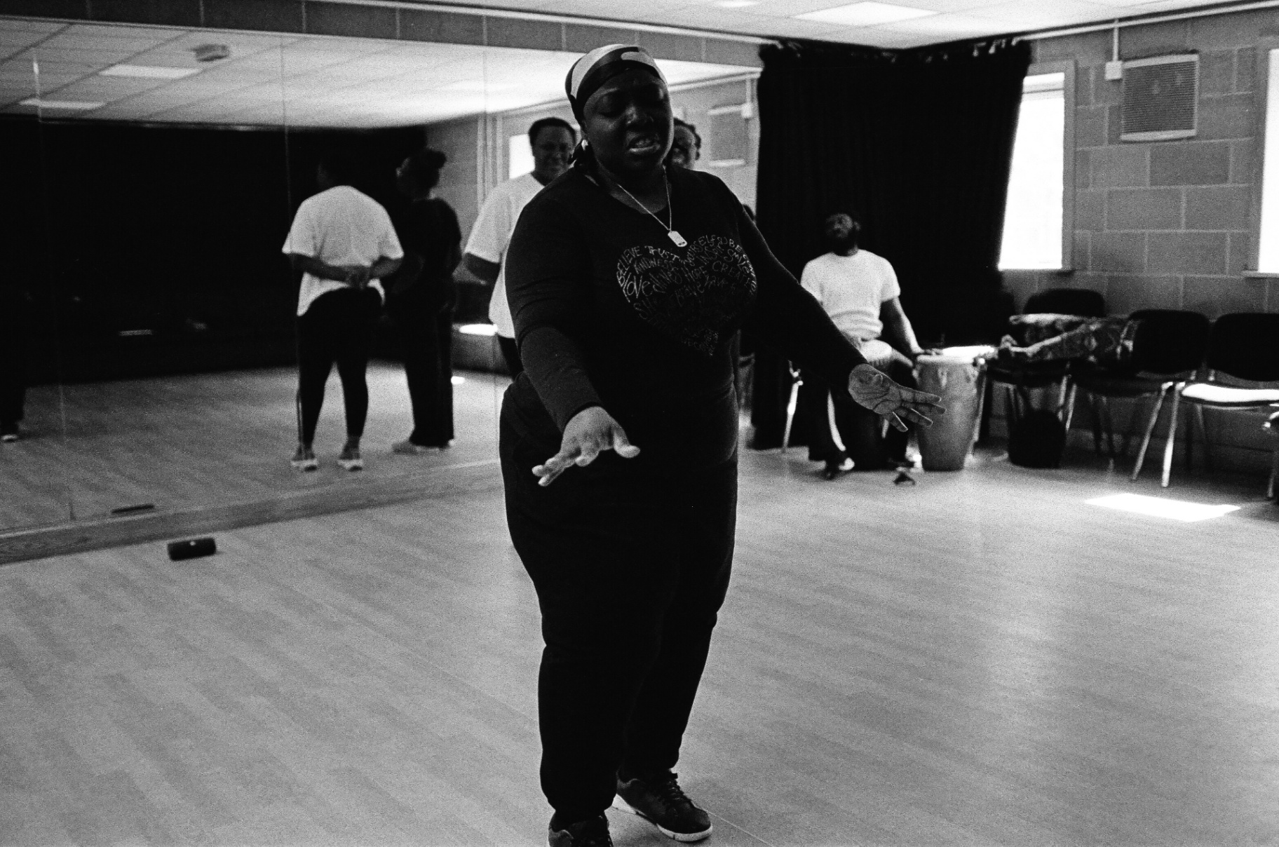 Singer mid-performance in rehearsal studio, black and white