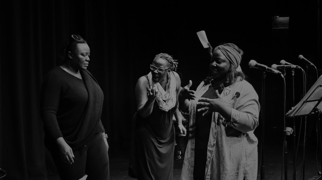 Three performers in rehearsal