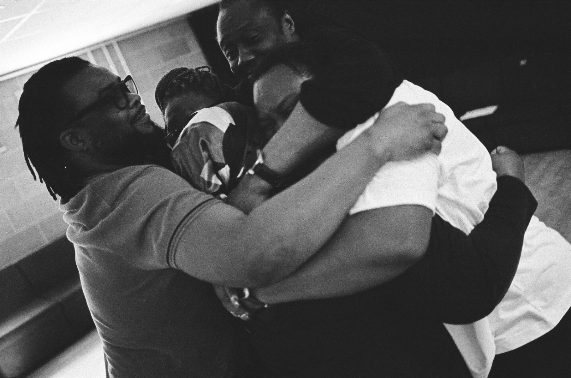 Company embracing in a group hug, black and white